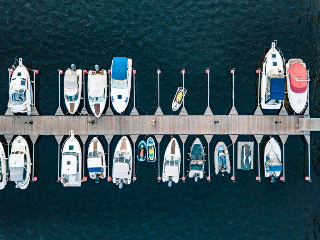 Aerial view of boats jet ski in dock in summer Finland. Colorful landscape sailboats and motorboats