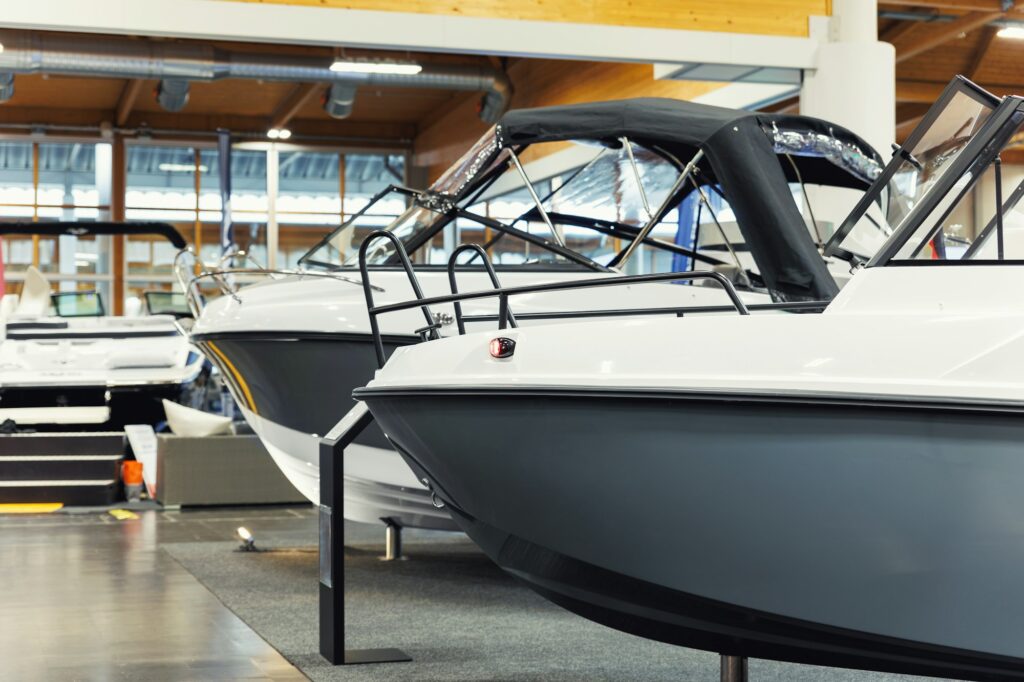 Many small big ship yachts at boat show exhibition indoors hall. Marine fishing yachting sailing